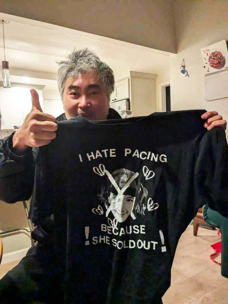 Mike Park of Asian Man Records holding initial t-shirt print run giving one thumb up.